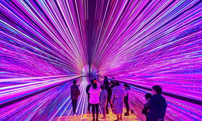 People walking through a bright tunnel of colors