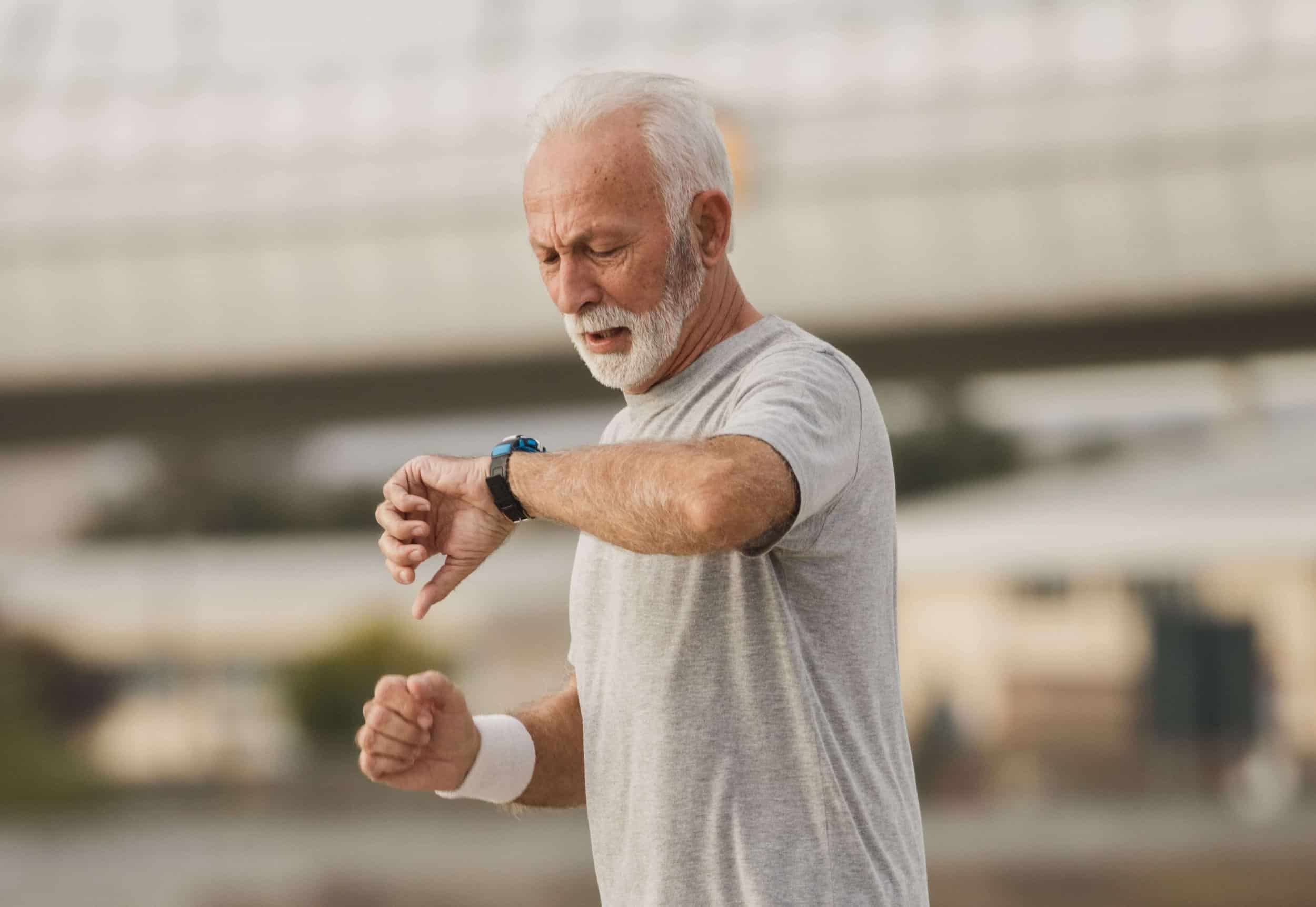 Old man running with a smartwatch as fitness tracker